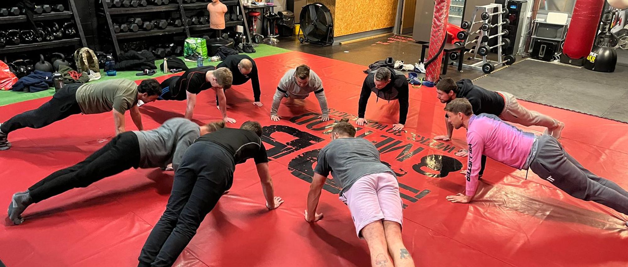 A Cali Fit class doing a pressup challenge on the floor