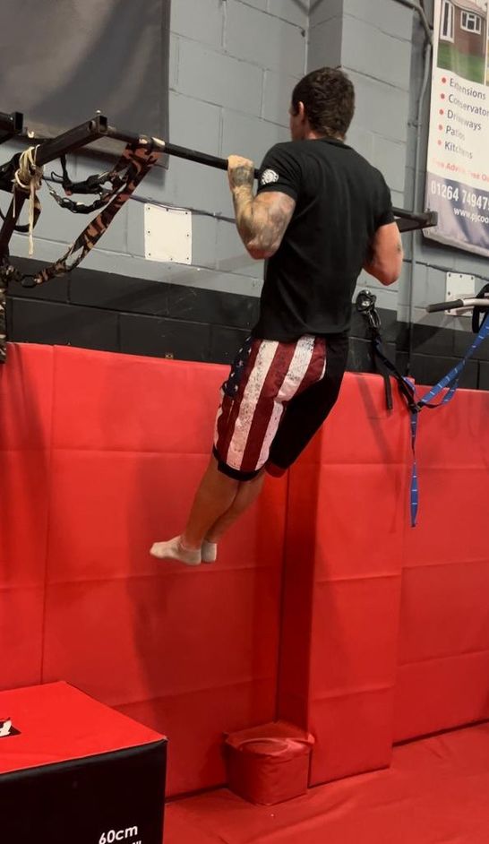 John, a calisthenics coach, performing a pull up